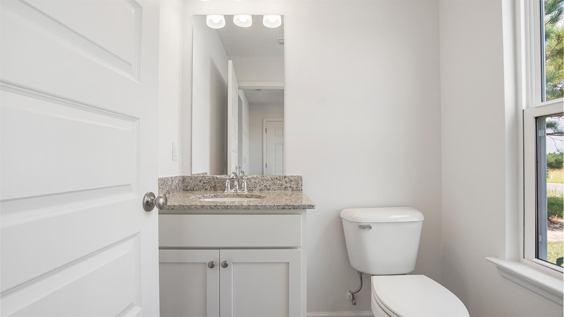 226 Huckleberry Street Freeport, FL 32439 - Photo 5 of 32 a bathroom with a granite countertop toilet sink and mirror