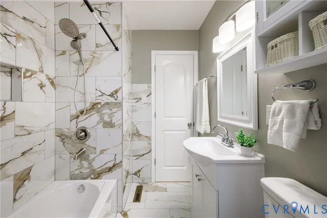 a bathroom with a sink vanity granite toilet and shower