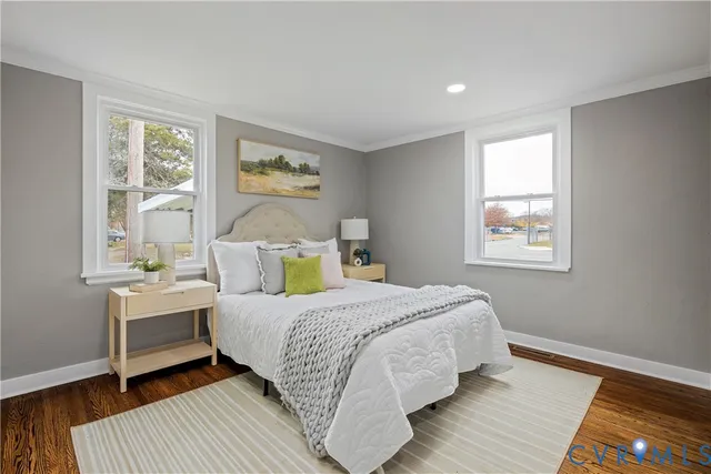 a bedroom with a bed wooden floor and window