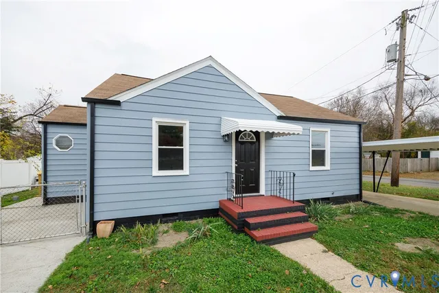 a backyard of a house with wooden deck and outdoor seating