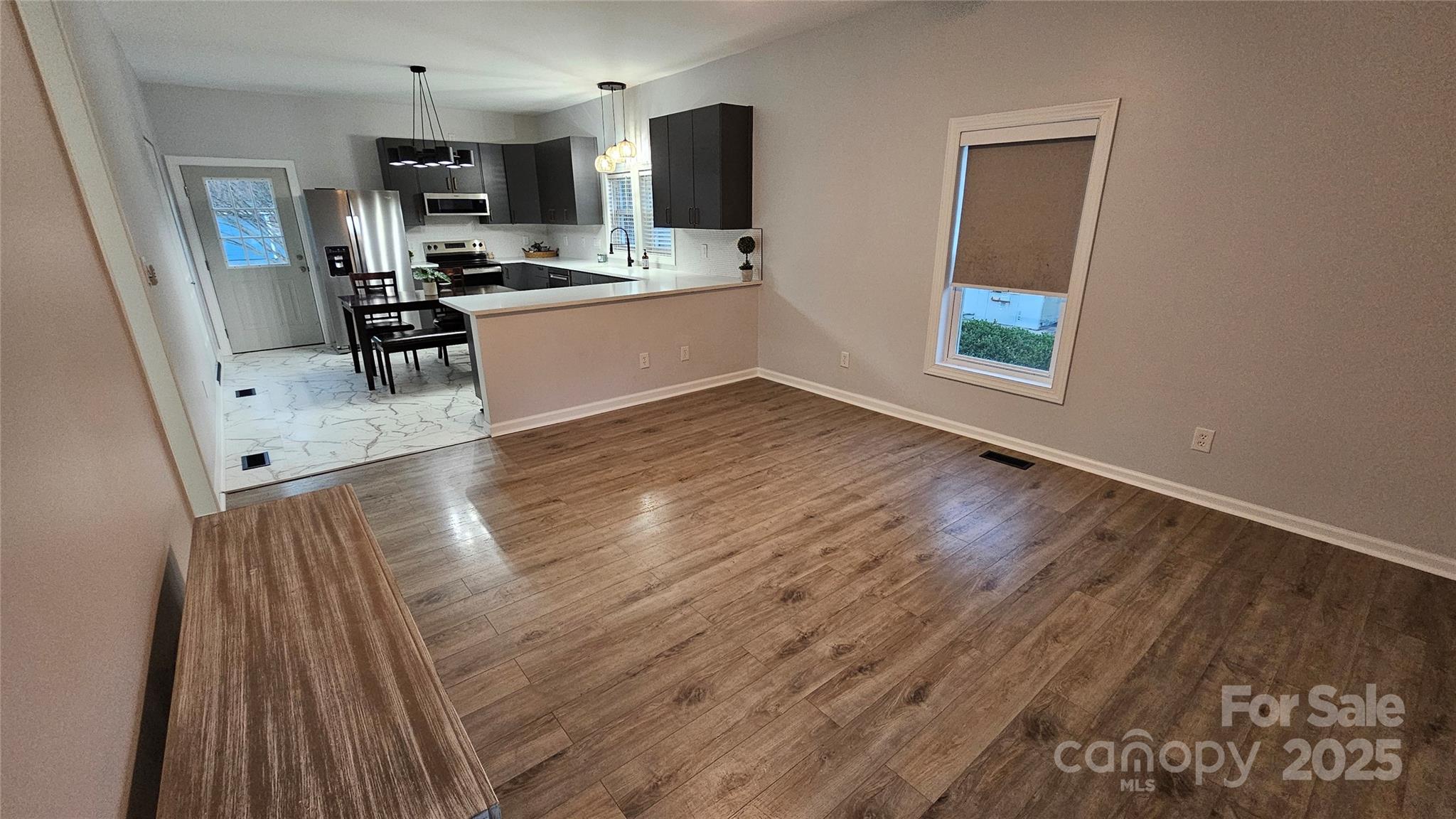 202 Williamson Street Fort Mill, SC 29715 - Photo 8 of 24 a view of a kitchen with fridge and wooden floor