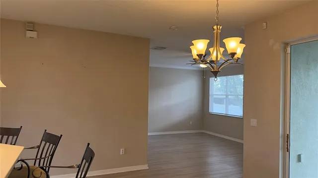 a view of a room with chairs and wooden floor