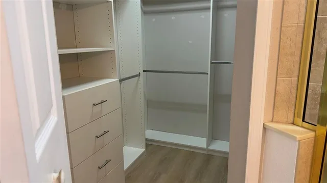 a view of a small space with wooden floor and a window