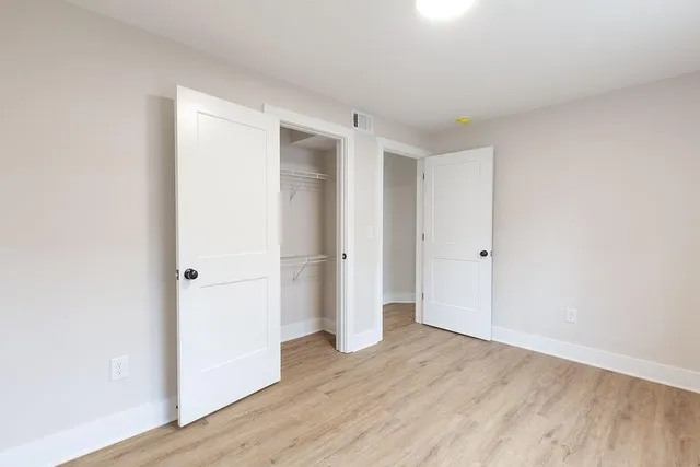 a view of empty room with wooden floor