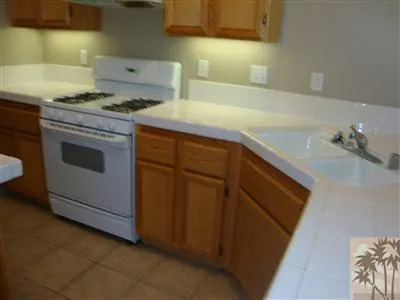 a kitchen with granite countertop cabinets and white stove