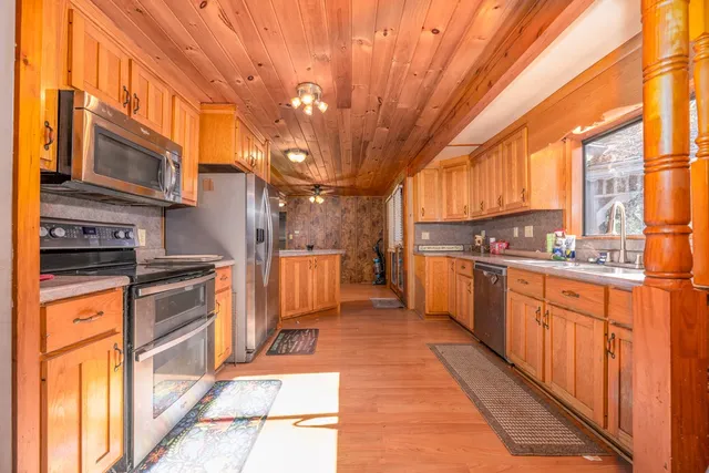 a kitchen with stainless steel appliances granite countertop a refrigerator a stove top oven and cabinets