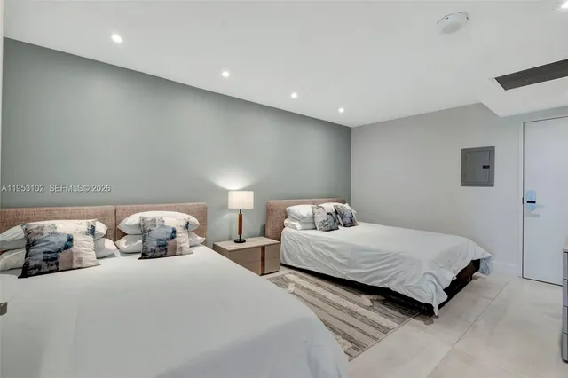 a bedroom with two beds and a lamp