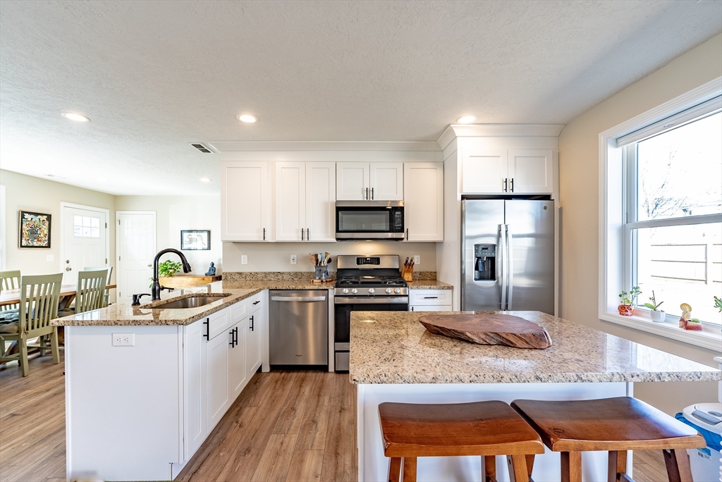 20 Ormond Drive Northampton, MA 01062 - Photo 8 of 32 a kitchen with stainless steel appliances granite countertop a stove top oven a sink dishwasher and a refrigerator with wooden floor
