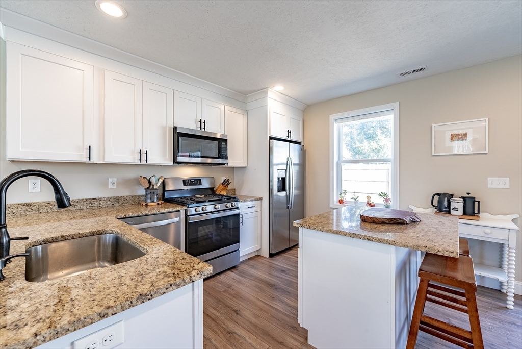 20 Ormond Drive Northampton, MA 01062 - Photo 9 of 32 a kitchen with a stove a sink a microwave and wooden cabinets