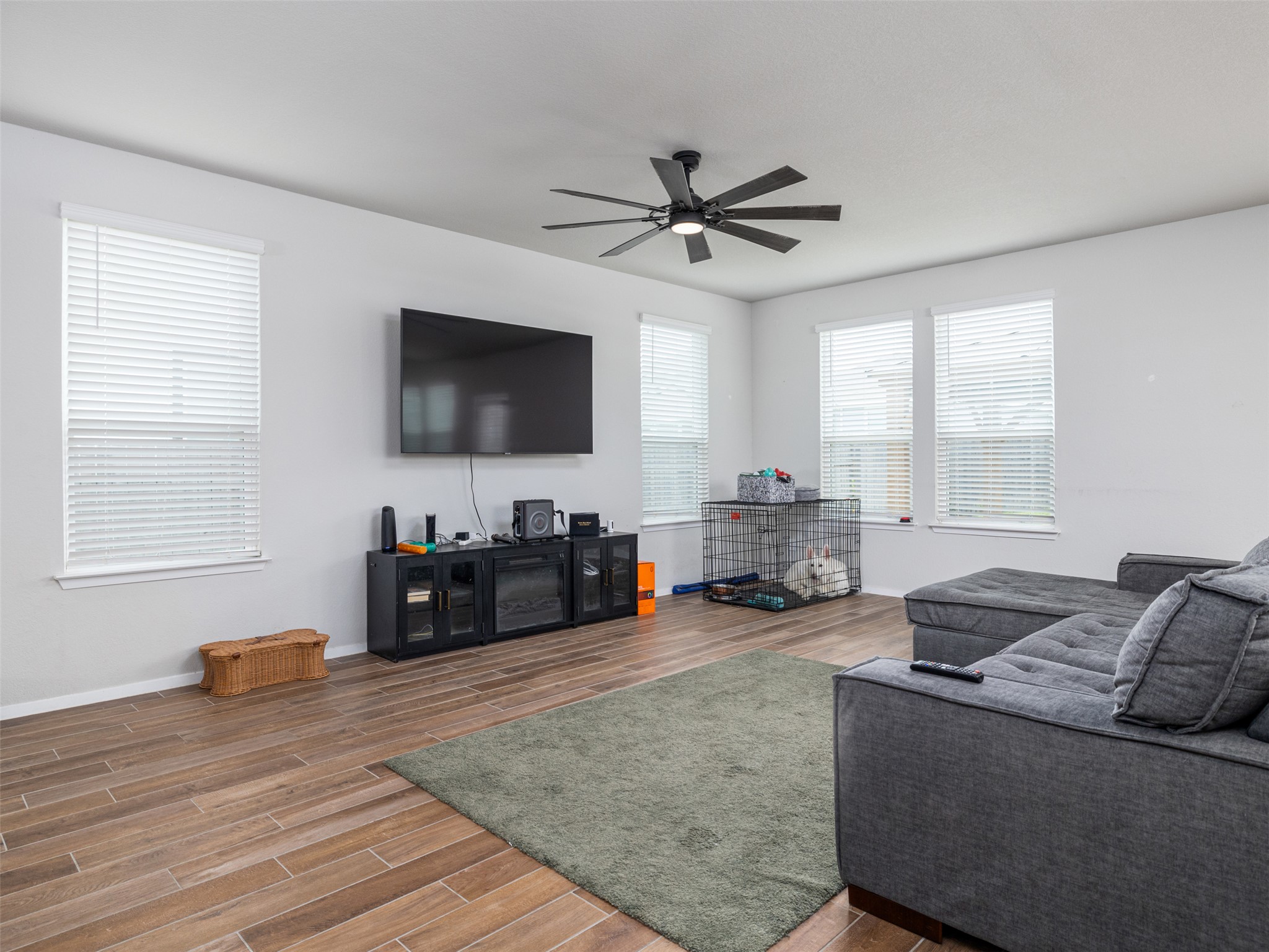 121 Graver Street Georgetown, TX 78626 - Photo 5 of 28 A relaxed living area showcasing abundant natural light and rich wood-look flooring.