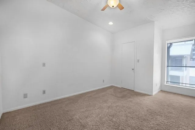 an empty room with a empty space and a ceiling fan