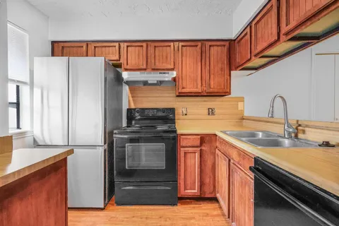 a kitchen with stainless steel appliances granite countertop a refrigerator and a sink