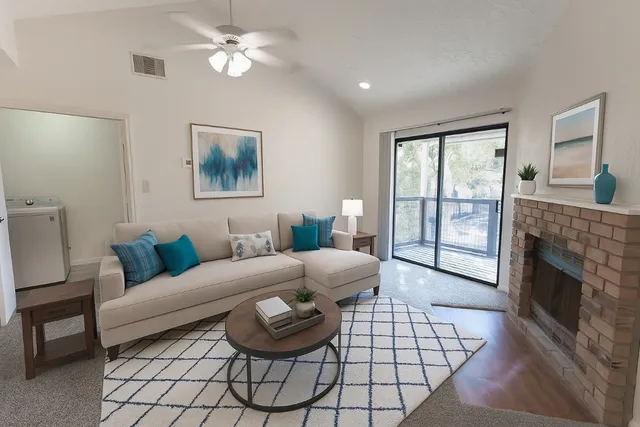 a living room with furniture a fireplace and a flat screen tv