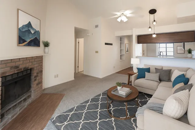 a living room with furniture a flat screen tv and a fireplace