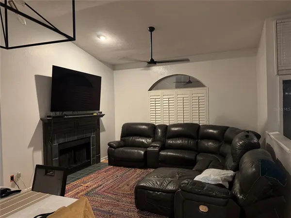 a living room with furniture a flat screen tv and a fireplace