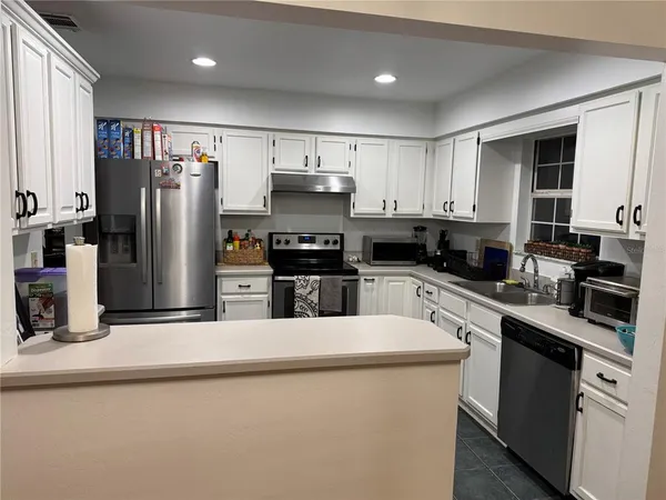 a kitchen with stainless steel appliances a refrigerator sink and microwave