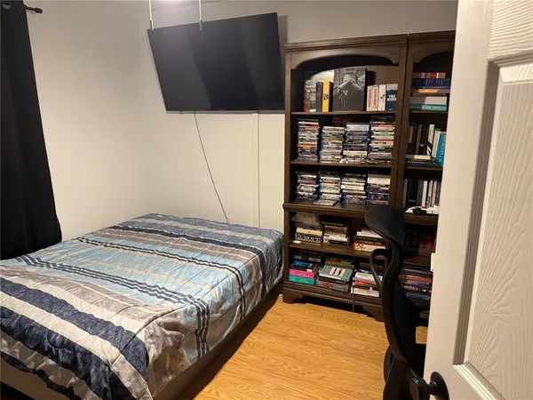 a bedroom with a bed a mirror and shelf