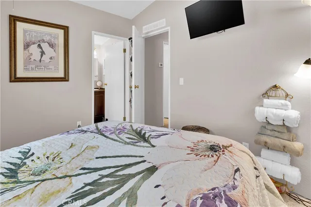 a bedroom with a bed and flat screen tv