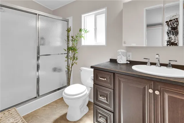 a bathroom with a granite countertop sink toilet and shower