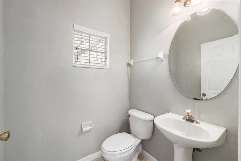 3151 Sinclair Street, Unit 101 Orlando, FL 32835 - Photo 6 of 18 a bathroom with a sink a mirror and a toilet