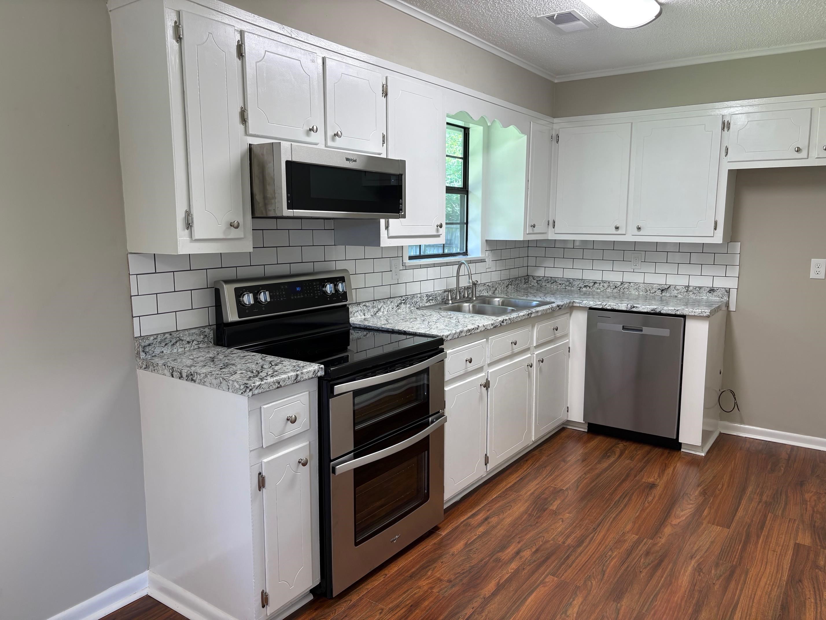 306 Robin Drive Ripley, TN 38063 - Photo 8 of 17 a kitchen with stainless steel appliances granite countertop a stove a sink and a microwave