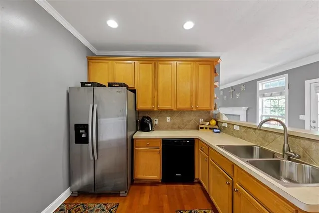 a kitchen that has a sink a refrigerator and cabinets