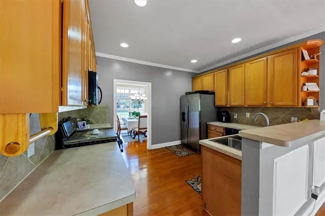a kitchen with stainless steel appliances granite countertop sink refrigerator and window