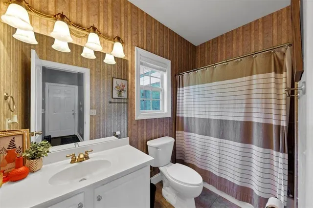 a bathroom with a sink a toilet and shower curtain