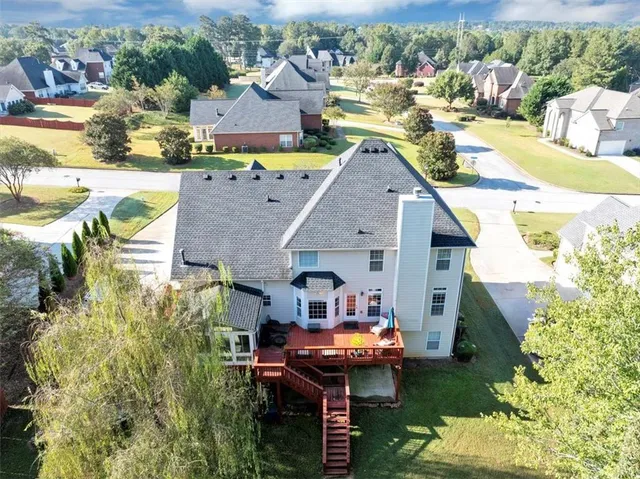 a aerial view of a house with swimming pool and large trees