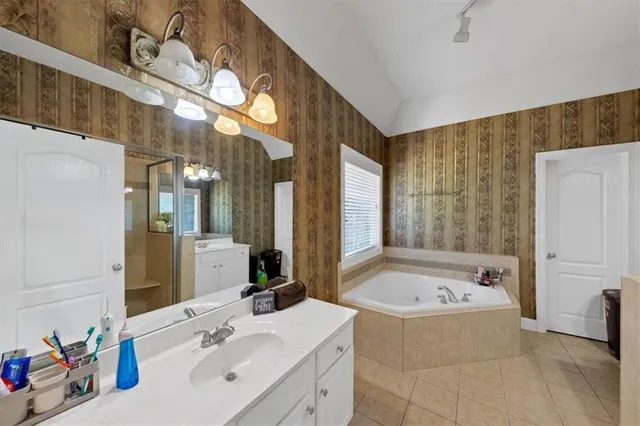 a bathroom with a tub sink and mirror