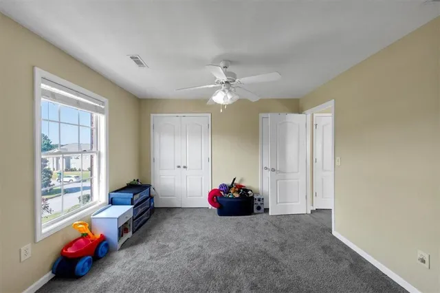 a bedroom with a bed a dresser and a chandelier