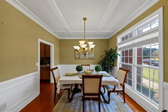 a dining room with furniture a chandelier and wooden floor