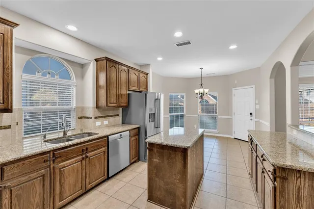 a kitchen with stainless steel appliances granite countertop a sink counter space cabinets and a large window