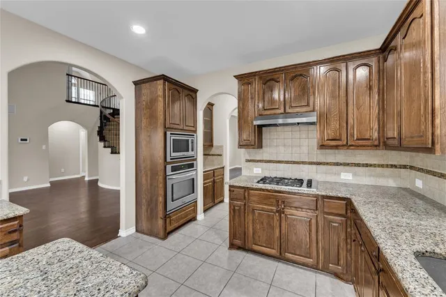a kitchen with stainless steel appliances granite countertop a refrigerator and a sink