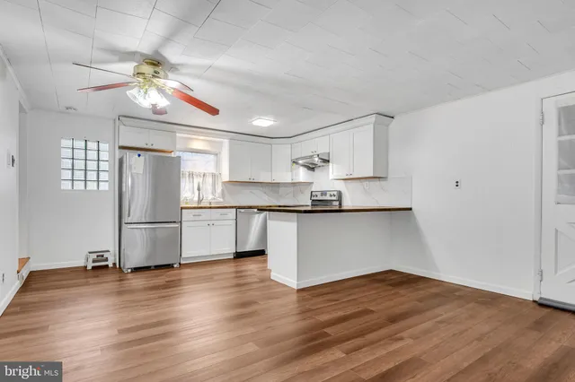 a view of a room with wooden floor and small window