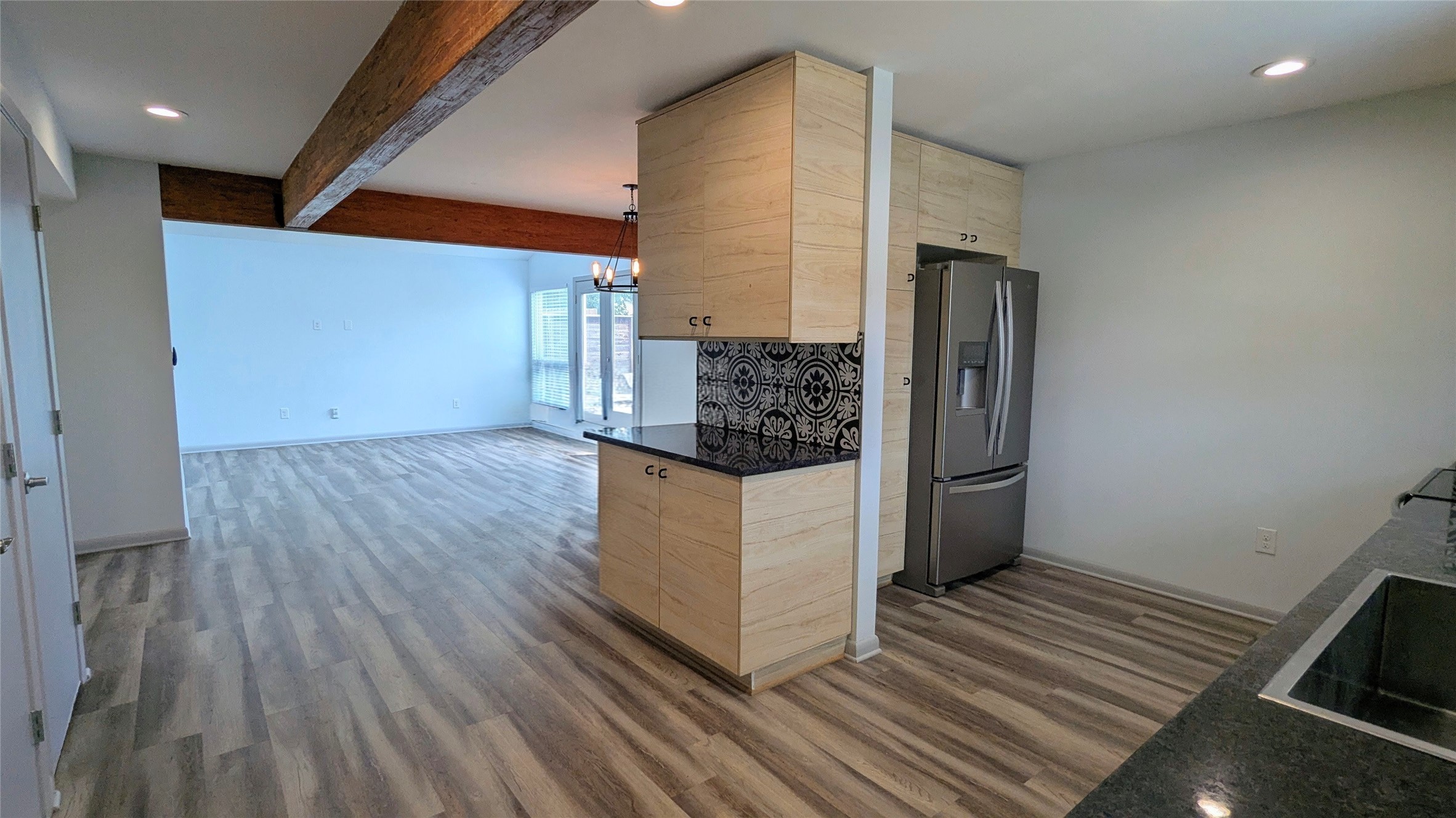 4505 Teri Road, Unit A Austin, TX 78744 - Photo 2 of 23 Modern kitchen with granite counters opens to a spacious living area with exposed beam accents.