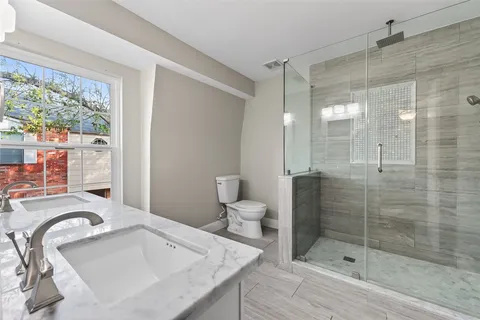 a bathroom with a granite countertop sink mirror and shower