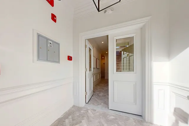 a view of a hallway to rooms and stairs