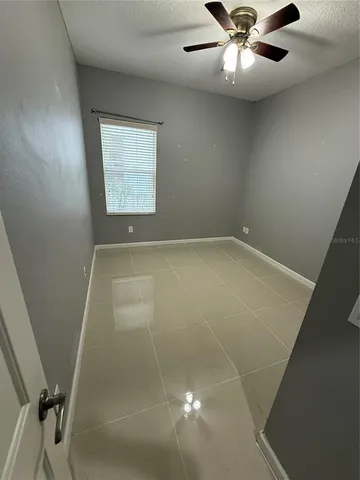 en empty room with windows and fan