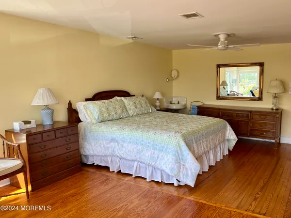 a bedroom with a bed and painting on the wall