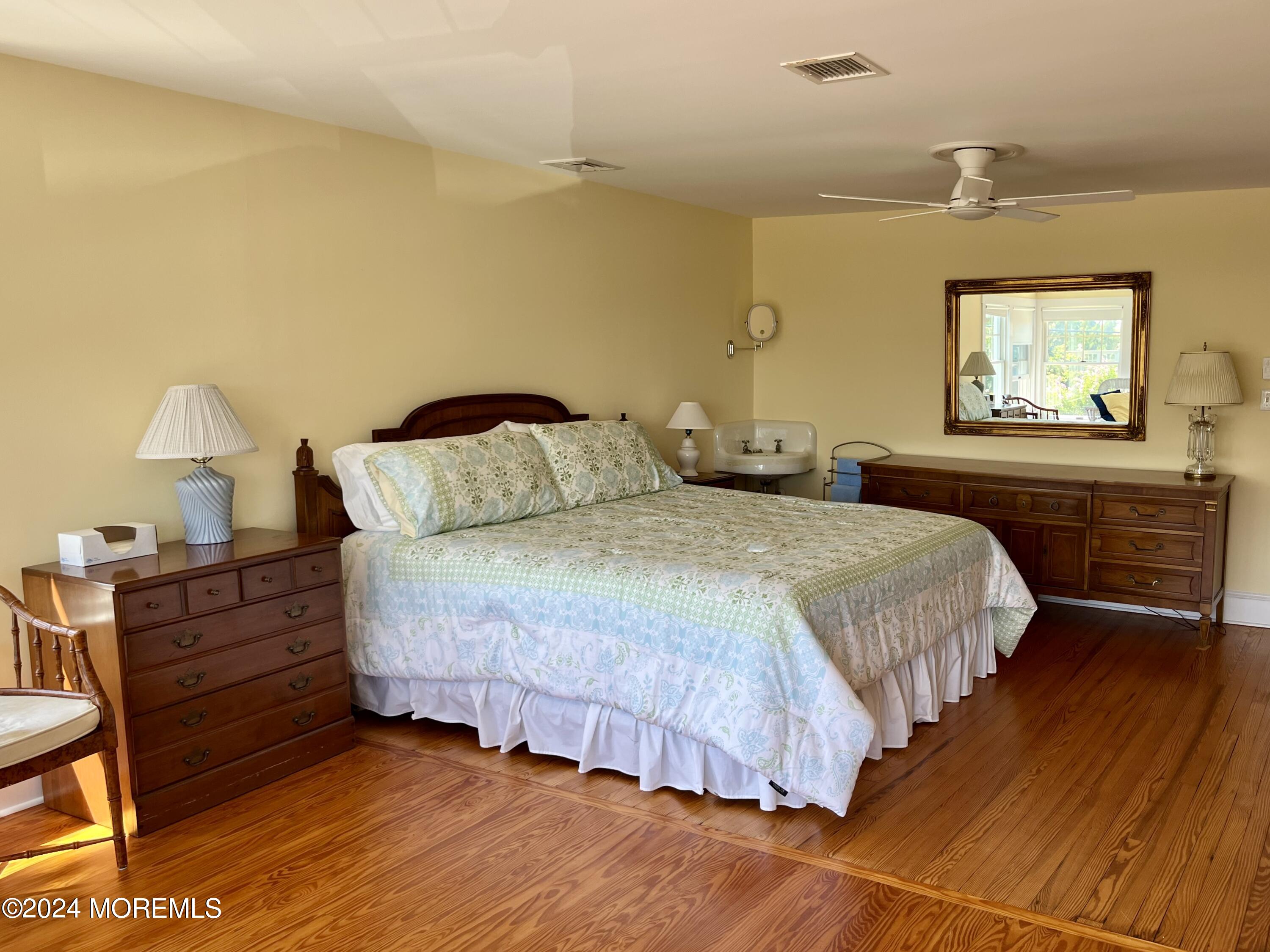 724 East Avenue, Unit SUMMER Bay Head, NJ 08742 - Photo 11 of 16 a bedroom with a bed and painting on the wall