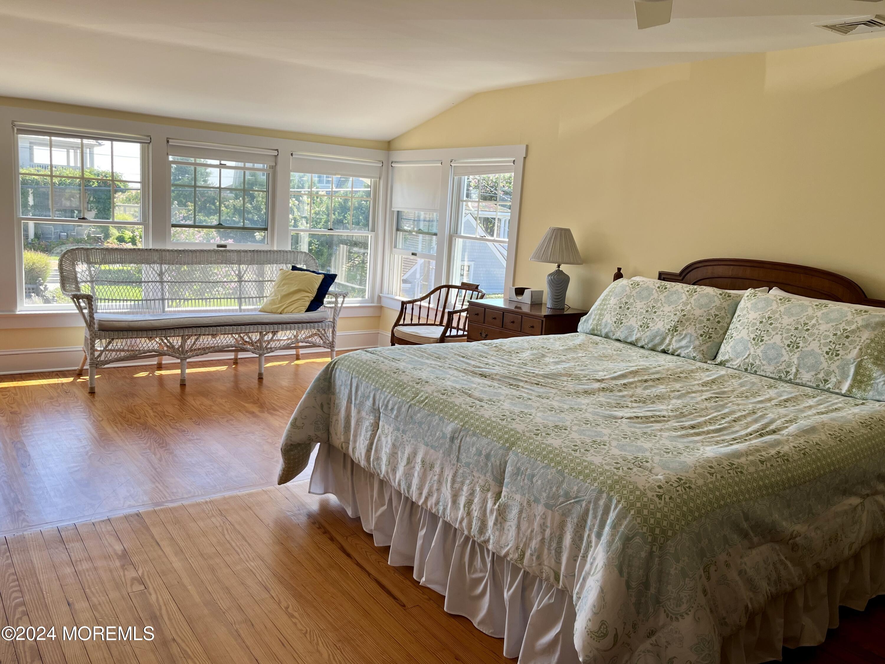 724 East Avenue, Unit SUMMER Bay Head, NJ 08742 - Photo 12 of 16 a spacious bedroom with a bed a table and windows