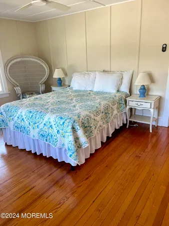 a bedroom with bed and wooden floor