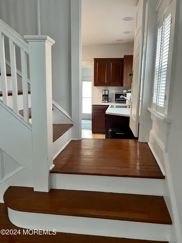 a view of kitchen with kitchen island a sink wooden floor and view living room