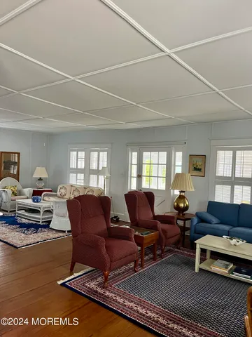 a living room with furniture a flat screen tv and a large window