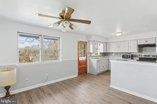 a kitchen with white cabinets and wooden floor