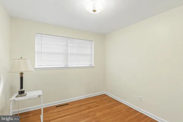 a view of a room with wooden floor and a window