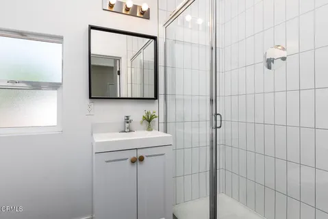 a bathroom with a sink a mirror and shower