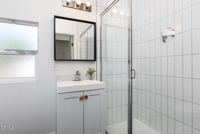 a bathroom with a sink a mirror and shower