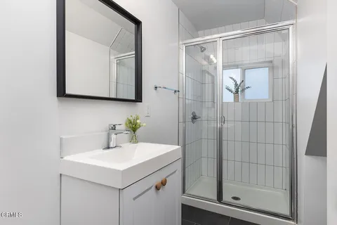 a bathroom with a sink a mirror and shower